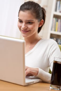 Students - Happy teenager with laptop in modern lounge sitting on armchair