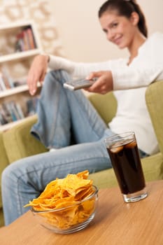 Students - Smiling female teenager watching television in living room