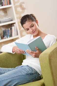 Students - Happy teenager with book sitting on armchair in lounge