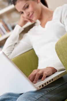 Students - Happy teenager with laptop in modern lounge sitting on armchair