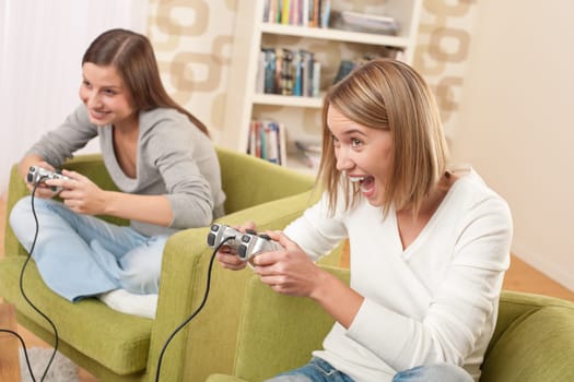 Students - Two female teenager playing video TV game in modern living room
