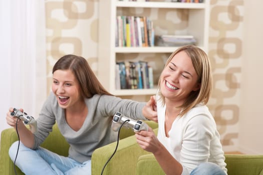Students - Two female teenager playing video TV game in modern living room