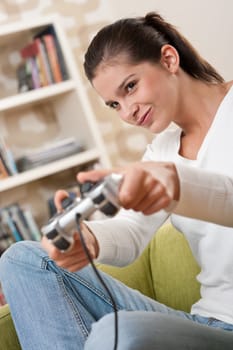 Students - Female teenager playing video game holding game pad in living room