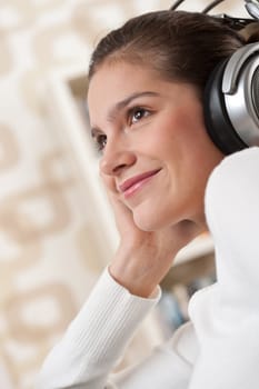 Students - Happy female teenager with headphones listening to music in modern lounge