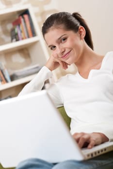 Students - Happy teenager with laptop in modern lounge sitting on armchair
