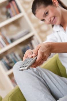 Students - Smiling female teenager with remote control in modern lounge