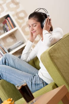 Students - Happy female teenager with headphones listening to music in modern lounge