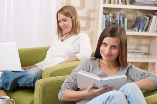 Students - Two female teenager studying sitting on green armchair
