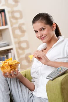 Students - Happy female teenager with potato chips in modern living room