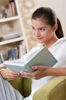 Students - Female teenager reading book in modern living room