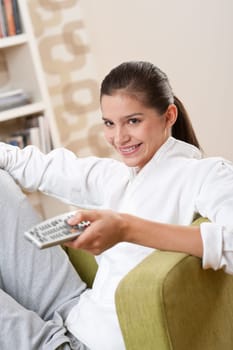 Students - Smiling female teenager with remote control in modern lounge
