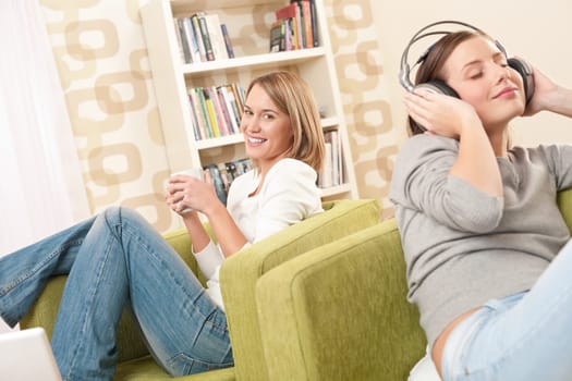 Students - Two female teenager relaxing in lounge having coffee and listening to music