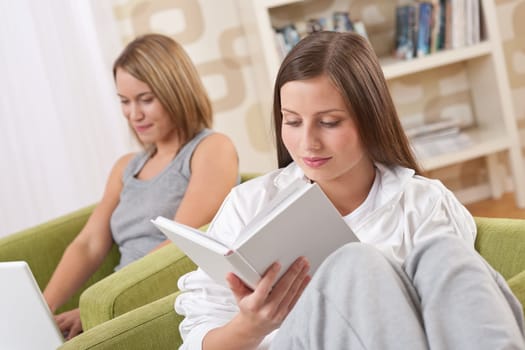 Students - Two female students studying in lounge, reading book