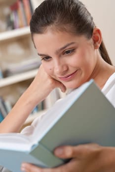 Students - Female teenager reading book in modern living room