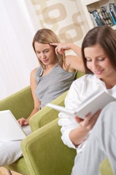 Students - Two female students studying in lounge, reading book