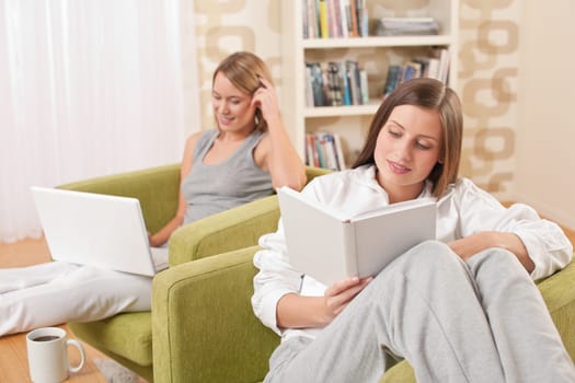Students - Two female students studying in lounge, reading book