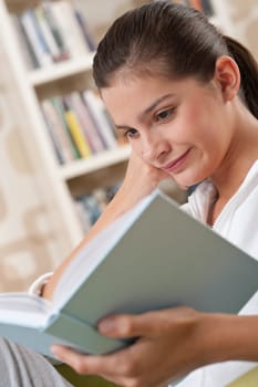 Students - Female teenager reading book in modern living room