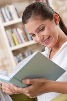 Students - Female teenager reading book in modern living room