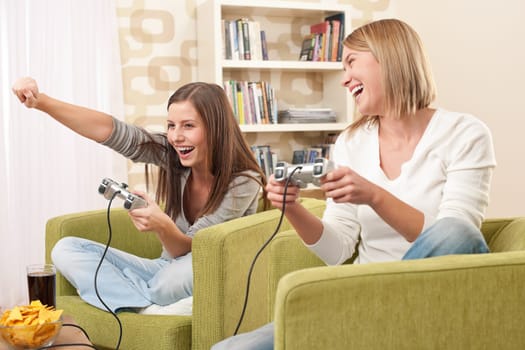 Students - Two female teenager playing video TV game in modern living room