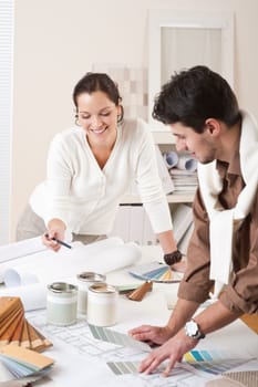Two interior designer working at office with color swatch and can of paint
