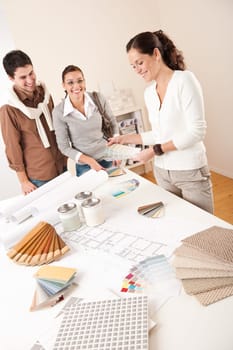 Female interior designer with two clients at office choosing colors