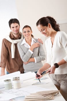 Female interior designer with two clients at office choosing colors