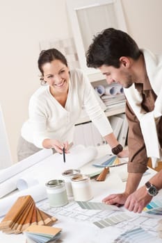 Two interior designer working at office with color swatch and can of paint