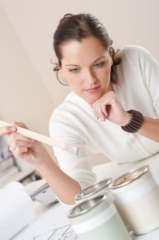 Female interior designer working at office with color swatch and paint