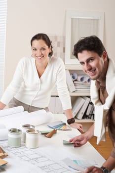Two interior designer working at office with color swatch and can of paint