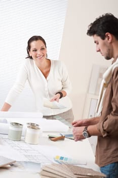 Two interior designer working at office with color swatch and can of paint