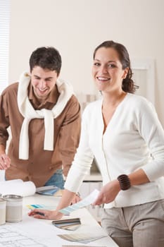 Two interior designer working at office with color swatch and can of paint