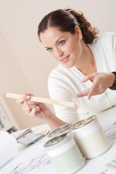 Female interior designer with cans of paint at office