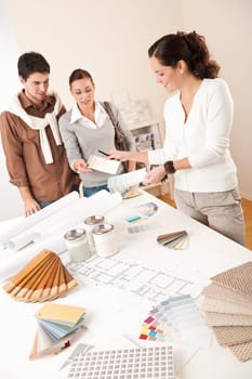 Female interior designer with two clients at office choosing colors