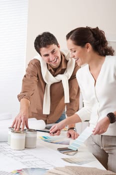Two interior designer working at office with color swatch and can of paint