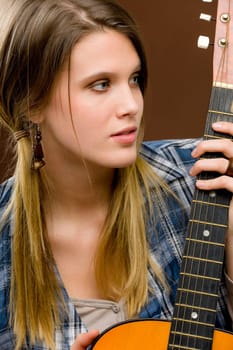 Rock musician - young fashion female model posing with guitar
