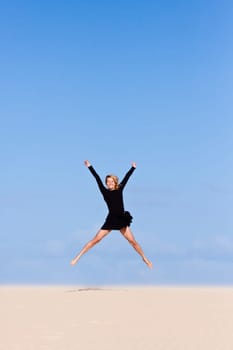 Beautifull girl jumping on the sand  dune.