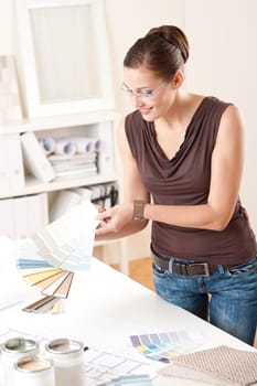 Young female designer working at office with color swatches