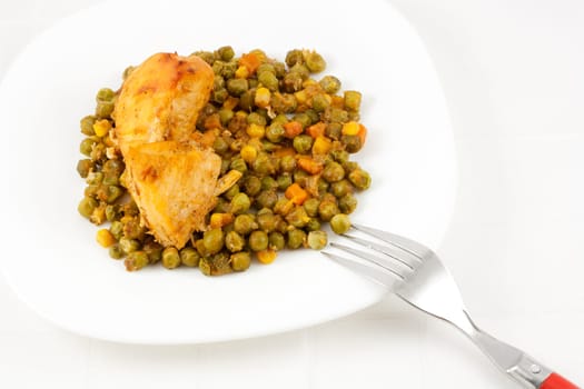 Healthy meal with baked chicken meat, carrots, peas, and corns.