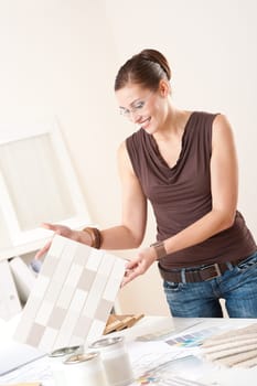 Female interior designer working at office with color swatch choosing color of tiles