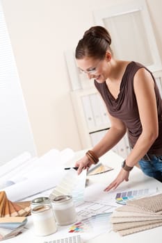 Young female designer working at office with color swatches