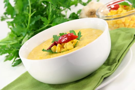 a bowl of corn soup with chili and parsley