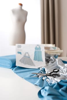 Fashion designer studio with professional equipment, sketches, mannequin, cloth