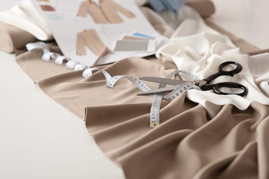 Fashion designer studio with professional equipment on desk, cloth, scissors