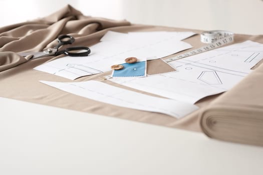 Fashion designer studio with professional equipment on desk, cloth, scissors