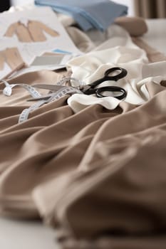 Fashion designer studio with professional equipment on desk, cloth, scissors