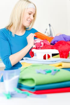 Laundry - woman folding clothes home, housework