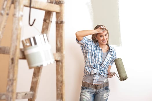Home improvement: Blond woman painting wall with paint roller