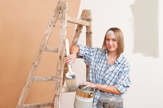 Home improvement: Smiling woman with paint and brush