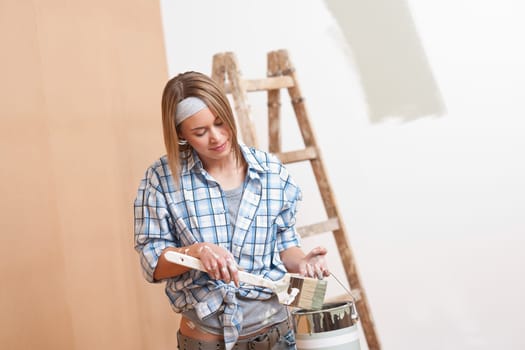 Home improvement: Smiling woman with paint and brush