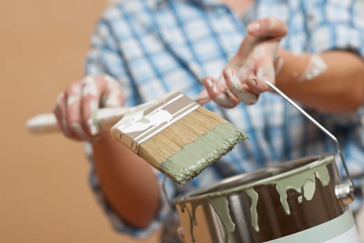 Home improvement: Woman holding paint brush and paint can